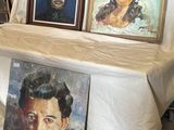 trois tableaux posés sur une table devant une tente