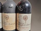 three bottles of red wine are lined up on a table