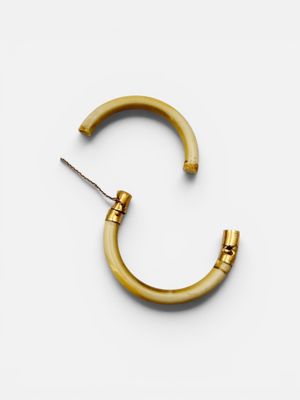 a close up of a pair of gold hoop earrings on a white surface