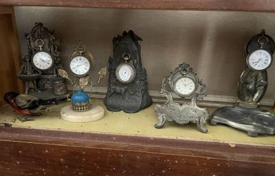 de nombreuses horloges différentes posées sur une étagère dans un meuble