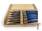 six knives in a wooden box on a white surface