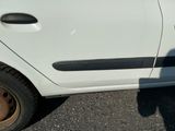 une petite voiture blanche avec un pneu crevé dans la rue