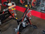many stationary bikes in a gym with mirrors on the wall