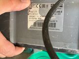 a hand that is holding an electronic device with a barcode on it