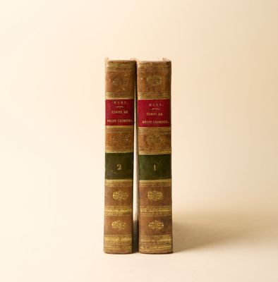 deux vieux livres posés l'un sur l'autre sur une surface blanche