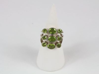 a close up of a ring with green stones on it