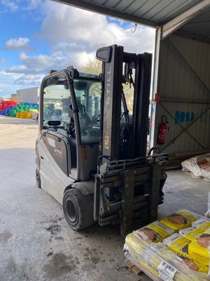 un chariot élévateur à fourche garé devant un bâtiment