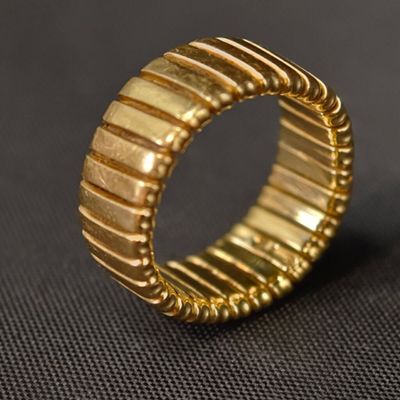 gros plan d'une bague en or sur une surface noire