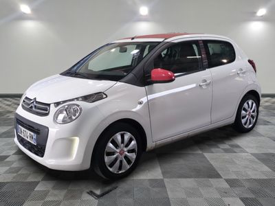 la petite voiture blanche est garée sur un carrelage à carreaux
