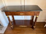 a small table with a marble top on a hard wood floor
