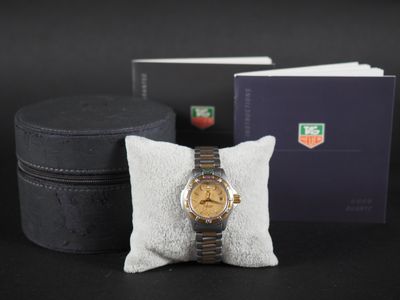 une montre posée sur un oreiller à côté d'une boîte