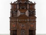une vieille armoire en bois ornée de sculptures élaborées sur le dessus