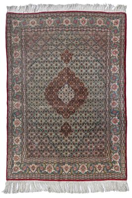 un tapis persan ancien, orné d'un motif en médaillon et de franges