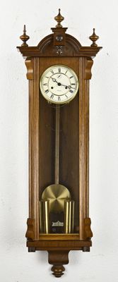 a wooden clock hanging on the wall next to a white wall