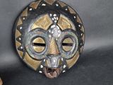 an image of a wooden mask hanging on a wall