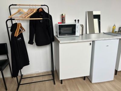une petite cuisine équipée d'un micro-ondes, d'un réfrigérateur et d'un étendoir à linge