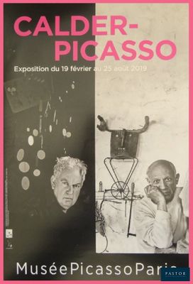 a black and white photo of two men in front of a pink poster
