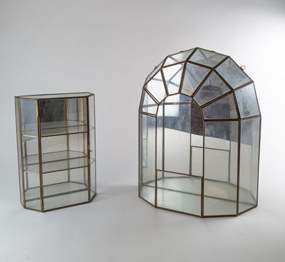 deux vitrines en verre, dotées de miroirs, posées sur un support blanc
