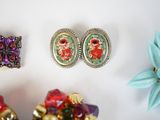 three different pieces of jewelry on a white surface