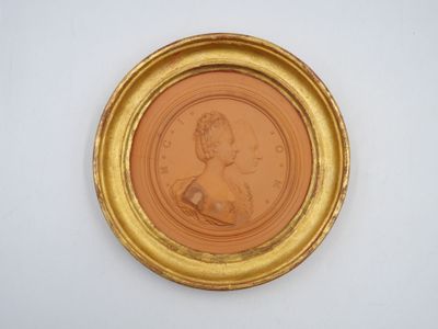 an old picture of a woman in a gold frame on a white wall
