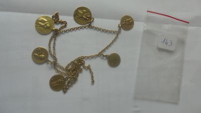 Gros plan sur un bracelet en or orné de pièces de monnaie