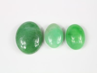 trois pierres de jade vert sur un fond blanc