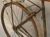 an old bicycle that is leaning against a wall