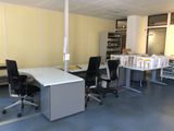 une photo d'une pièce avec un bureau et des chaises