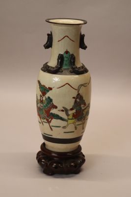 a vase with a painting on it sitting on a table