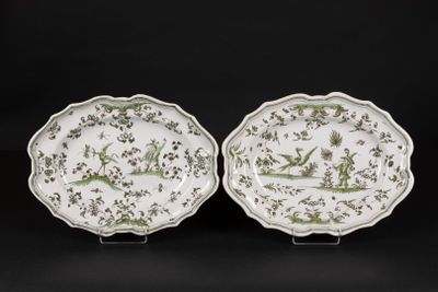 a pair of green and white plates with birds and flowers