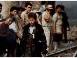 a young boy standing in front of a group of people