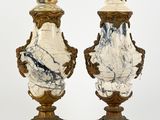 paire d'urnes anciennes en marbre, rehaussées de touches dorées, reposant sur des socles en marbre