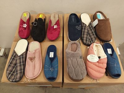 Plusieurs paires de chaussons sont alignées sur une table