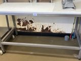 une table blanche sur laquelle se trouve un ordinateur portable, dans une pièce
