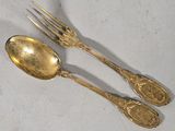 two spoons and a fork sitting on a table