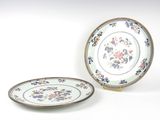 deux assiettes ornées de fleurs, posées sur un fond blanc