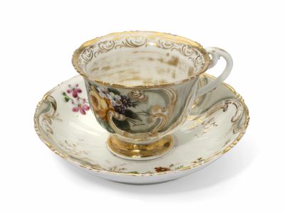 une tasse et une soucoupe sur une soucoupe sur une surface blanche