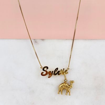 un collier plaqué or orné d'un éléphant et d'une plaque portant un prénom