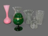 plusieurs vases en verre de différentes couleurs posés sur une surface grise