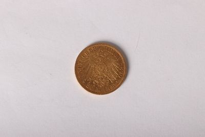 gros plan d'une pièce d'or sur une surface blanche