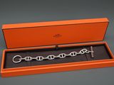 une boîte orange contenant un bracelet à chaîne argentée