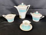 a close up of a tea set on a table with a black background