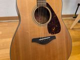 an acoustic guitar sitting on top of a hard wood floor