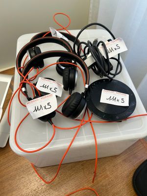 several headphones are sitting on top of a plastic container