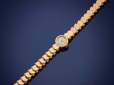 a gold wrist watch with a white dial on a blue background
