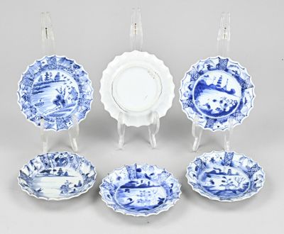 several blue and white plates and bowls are arranged in a circle