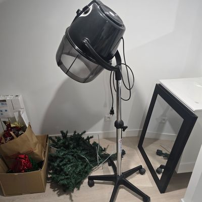 a lamp that is sitting on a tripod next to a christmas tree