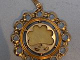a gold pendant with a picture of a cloud on it