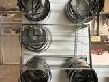 several pots and pans are hanging on a rack in a kitchen