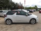 a small white car that is parked in a parking lot